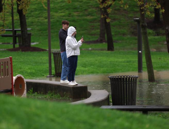 Two people take photos of flooding - April 6.JPG