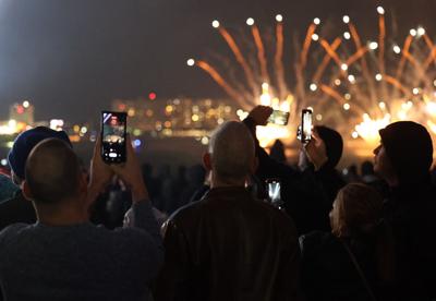 People record fireworks with phone.JPG