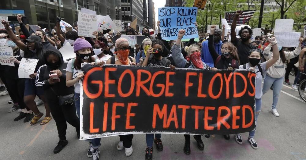 Protesters hold signs as they march during a protest.jpeg | | wdrb.com