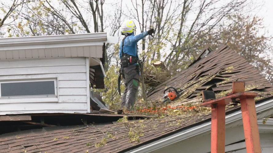 Crews work to remove tree that split a house in half during Wednesday's storms.