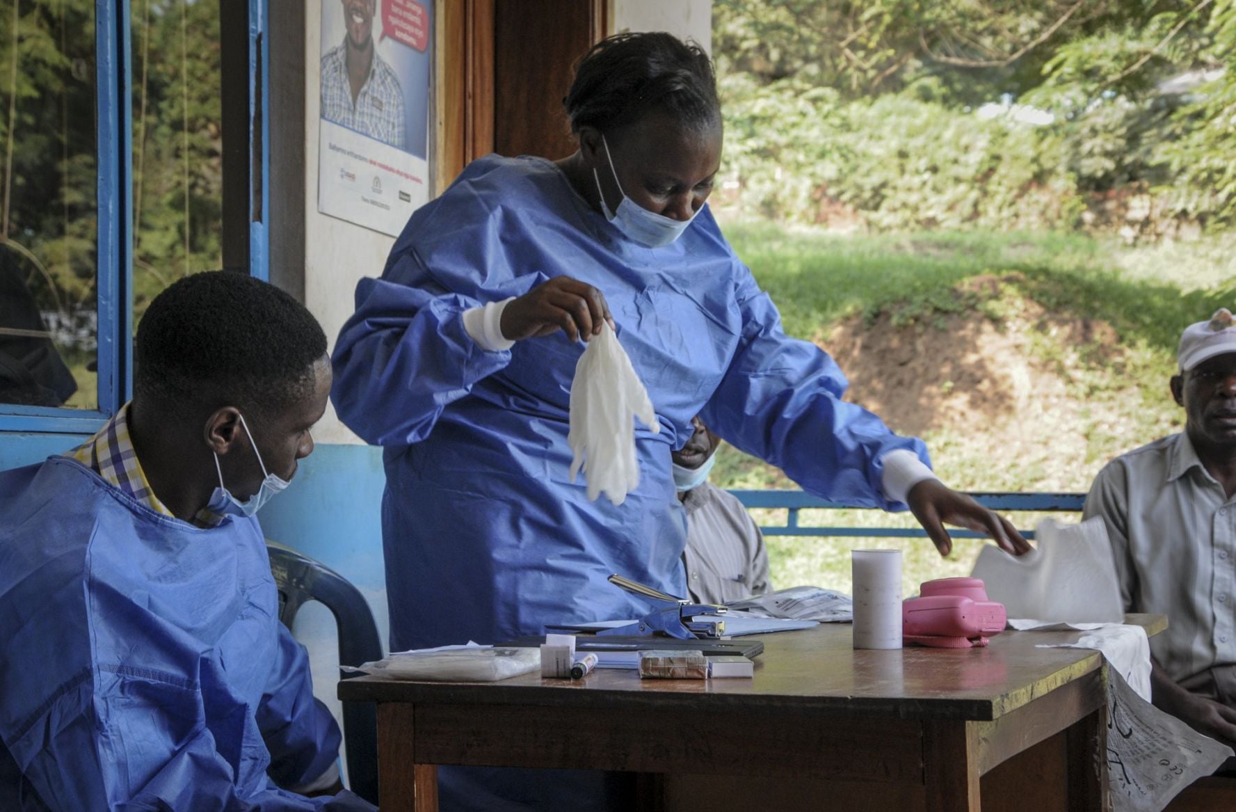 A health worker puts on her protective clothing