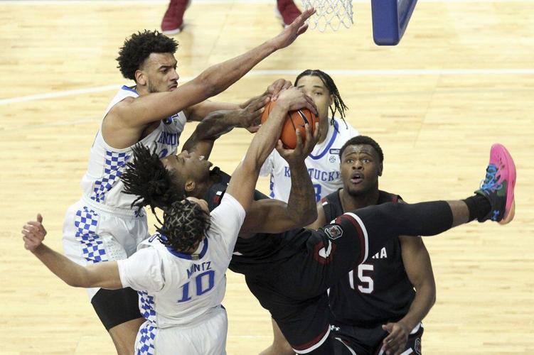 South Carolina's Trae Hannibal, center, has his shot blocked by Kentucky's Davion Mintz