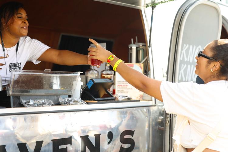 Vendor hands person a drink at Bourbon and Beyond.JPG