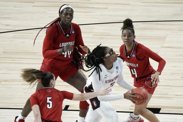 Stanford's Francesca Belibi drives between Louisville's Mykasa Robinson (5), Olivia Cochran (44) and Kianna Smith