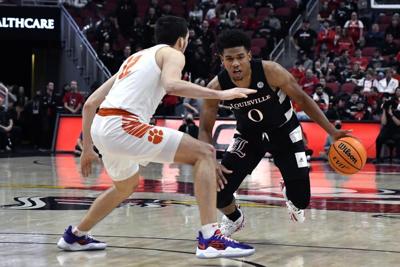 Louisville guard Noah Locke tries to drive past Clemson guard Alex Hemenway.jpeg