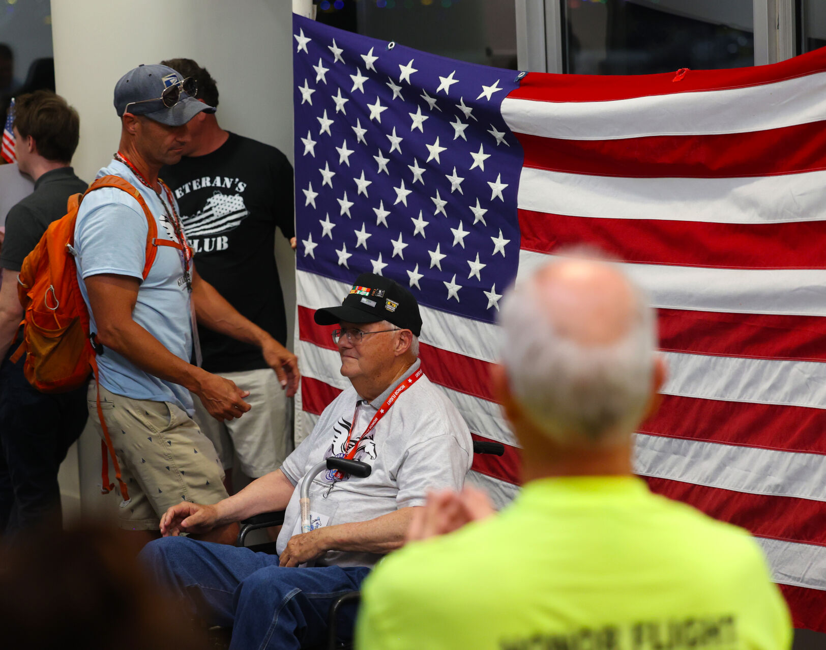 Veteran takes photo with flag at Honor Flight return home.JPG