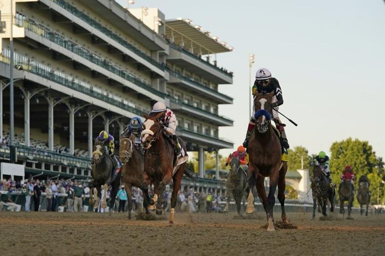 Authentic, right, crosses the finish line to win the 146th running of the Kentucky Derby