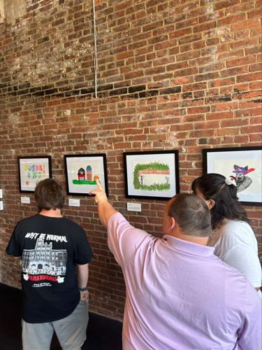 Artists review a Frazier History Museum exhibit showcasing work by artists with Down Syndrome
