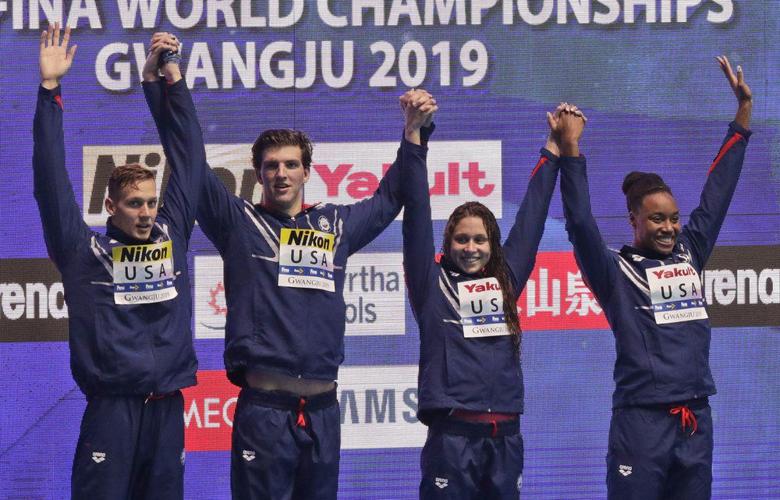Caeleb Dressel, Zach Apple, Mallory Comerford, and Simone Manuel stand on the podium