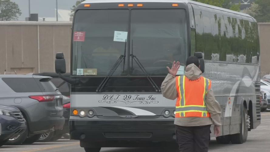 Parking lot attendant motions to shuttle bus at Churchill Downs