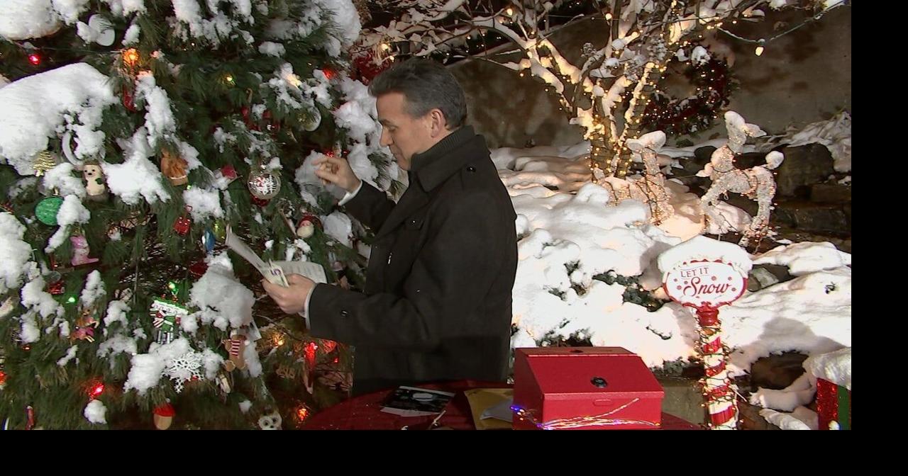 Jude rehangs an ornament buried in snow on the Jingle Tree | | wdrb.com