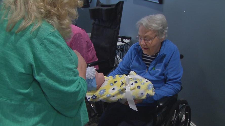 Senior with baby doll brought by Pearl's Memory Babies