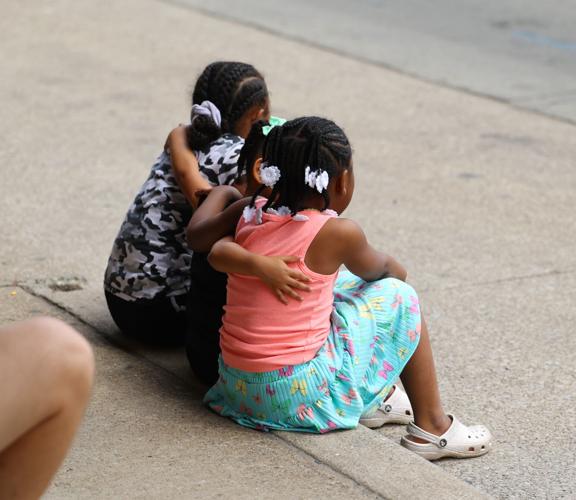 Children embrace and watch the parade.JPG