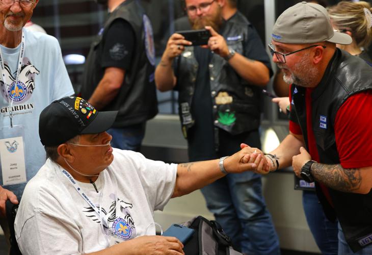 Man shakes hand of Vietnam veteran at Honor Flight Return Home.JPG