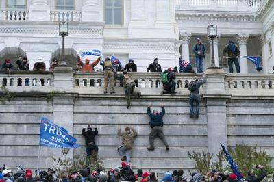 Supporters of President Donald Trump climb the west wall of the the U.S. Capitol on Wednesday, Jan. 6, 2021