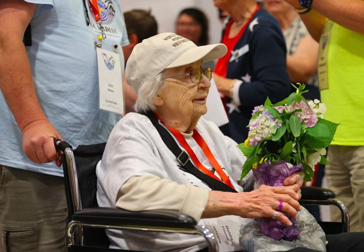 Veteran carries flowers during Honor Flight Return Home.JPG