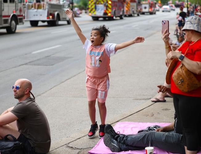 Child waves as the parade goes by.JPG