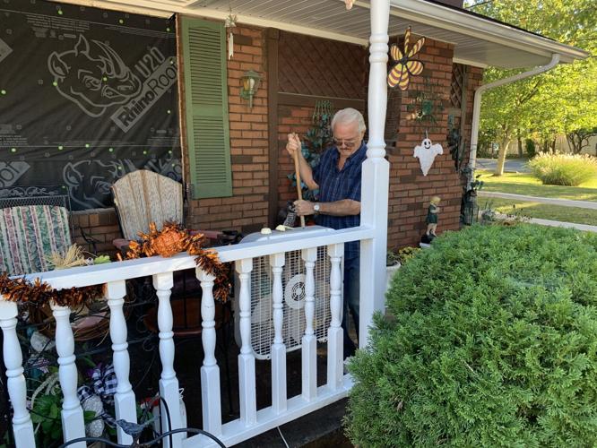 Hardin sweeping up porch at damaged home