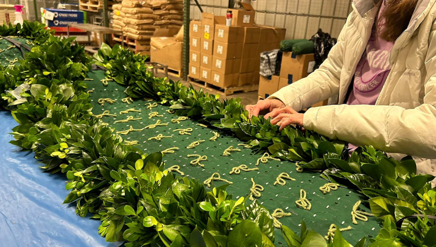 Kroger worker stitches roses garland