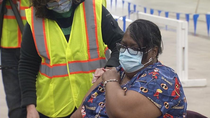 African American woman receiving COVID-19 vaccination at Broadbent Arena