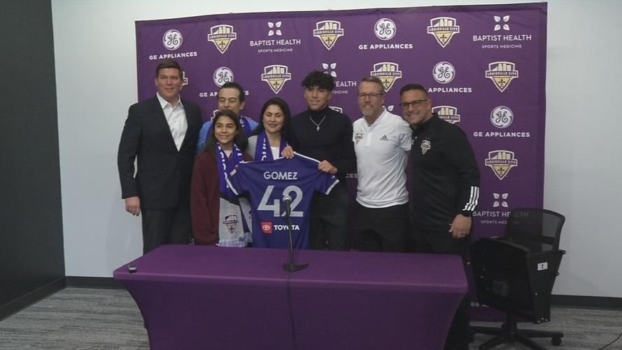 Jonathan Gomez holds Lou City jersey with family and coach, officials