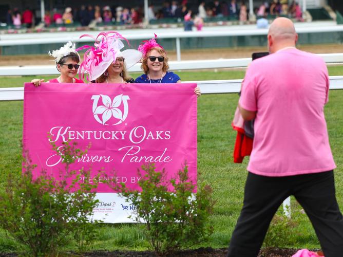 People take photo with Survivors Parade poster.JPG