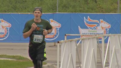 A runner crosses the finish line in the Humana Kentucky Derby Festival Marathon
