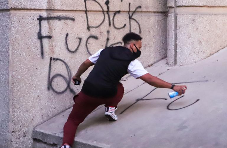 Protester spray paints 5-29-20 downtown louisville