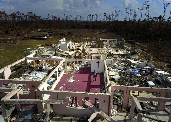 Pastor Jeremiah Saunders poses for a photo among the ruins of his church
