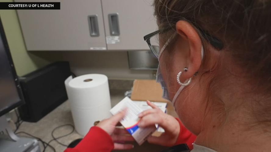 Pharmacy worker at UofL Health examines medication