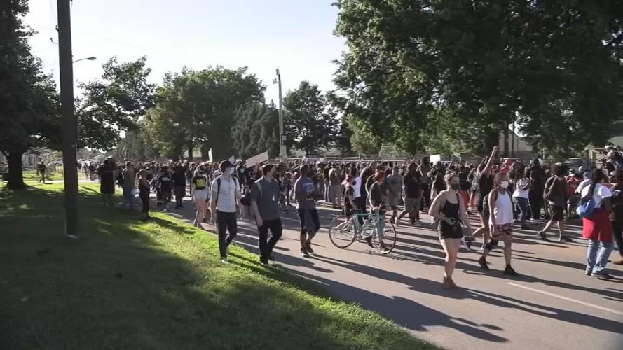 Churchill Downs protesters march past track