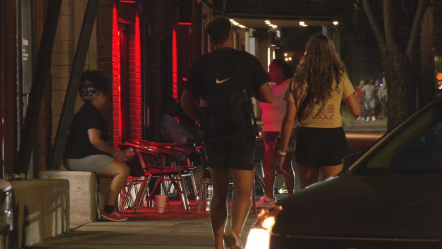 People walk down Bardstown Road at night