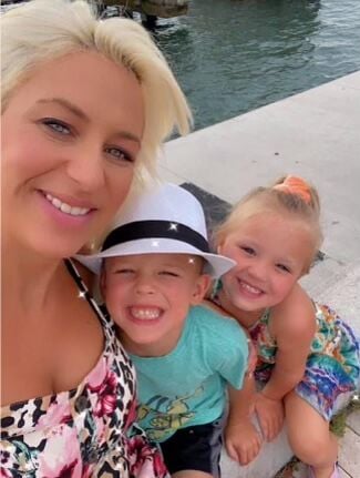 Katie Baunach smiles with two children ages 6 and 4.