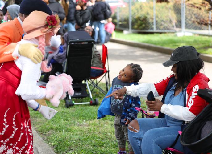 Clowns walk up to child at parade.JPG