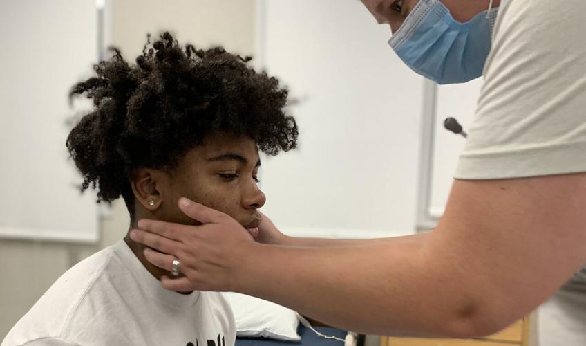 A JCPS student gets a free physical at Moore High School on July 11, 2022
