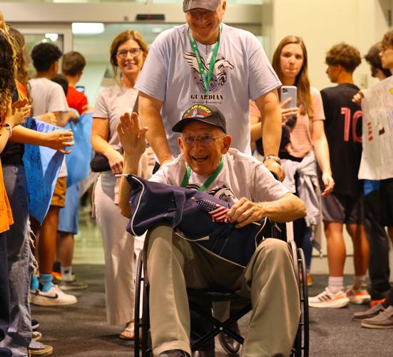 Veteran waves to the crowd before exiting Honor Flight Return Home.JPG