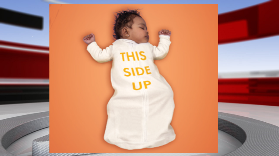 Sleeping baby with 'This Side Up' on onesie