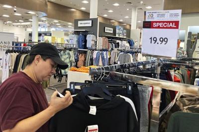 A customer checks price tags as she shops at a retail store.jpeg