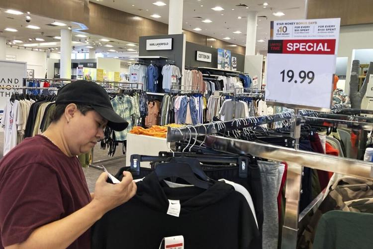 A customer checks price tags as she shops at a retail store.jpeg
