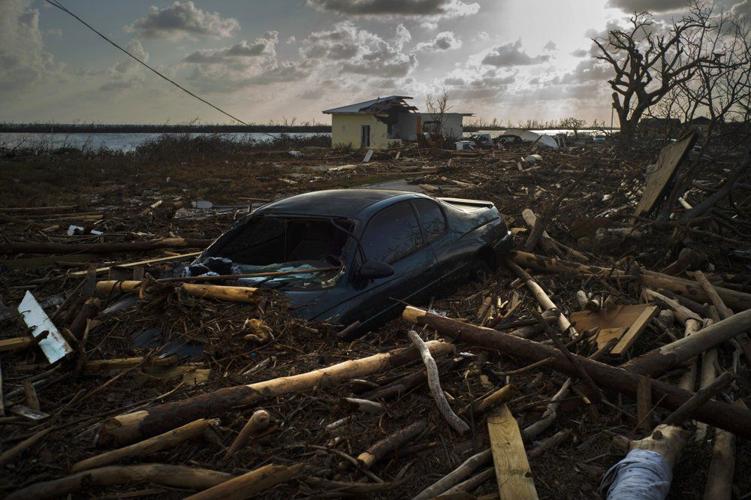 A car is sunk in the wreckage and debris caused by Hurricane Dorian