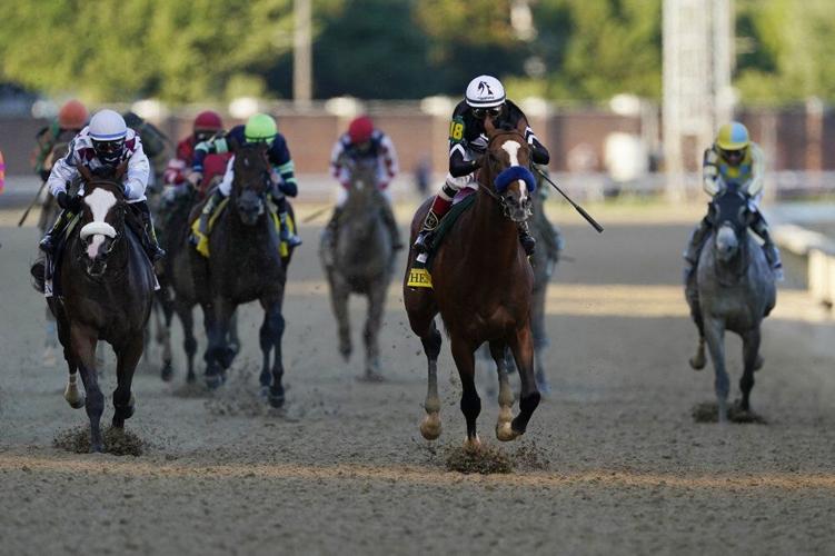 Authentic, second right, leads the field to win the 146th running of the Kentucky Derby at Churchill Downs