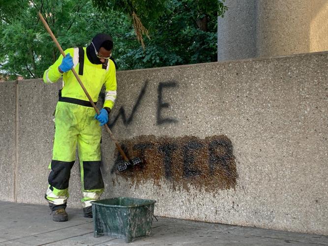 LMPD Protest - Worker cleans we matter graffiti at Hall of Justice
