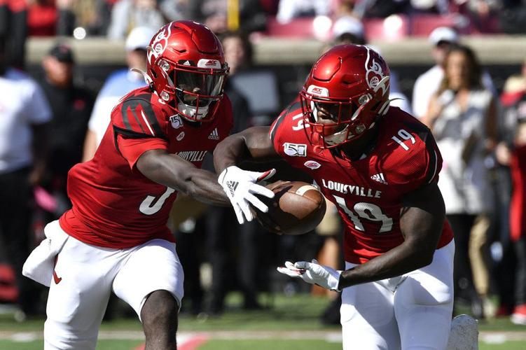 Louisville quarterback Micale Cunningham (3) hands the ball off to running back Hassan Hall