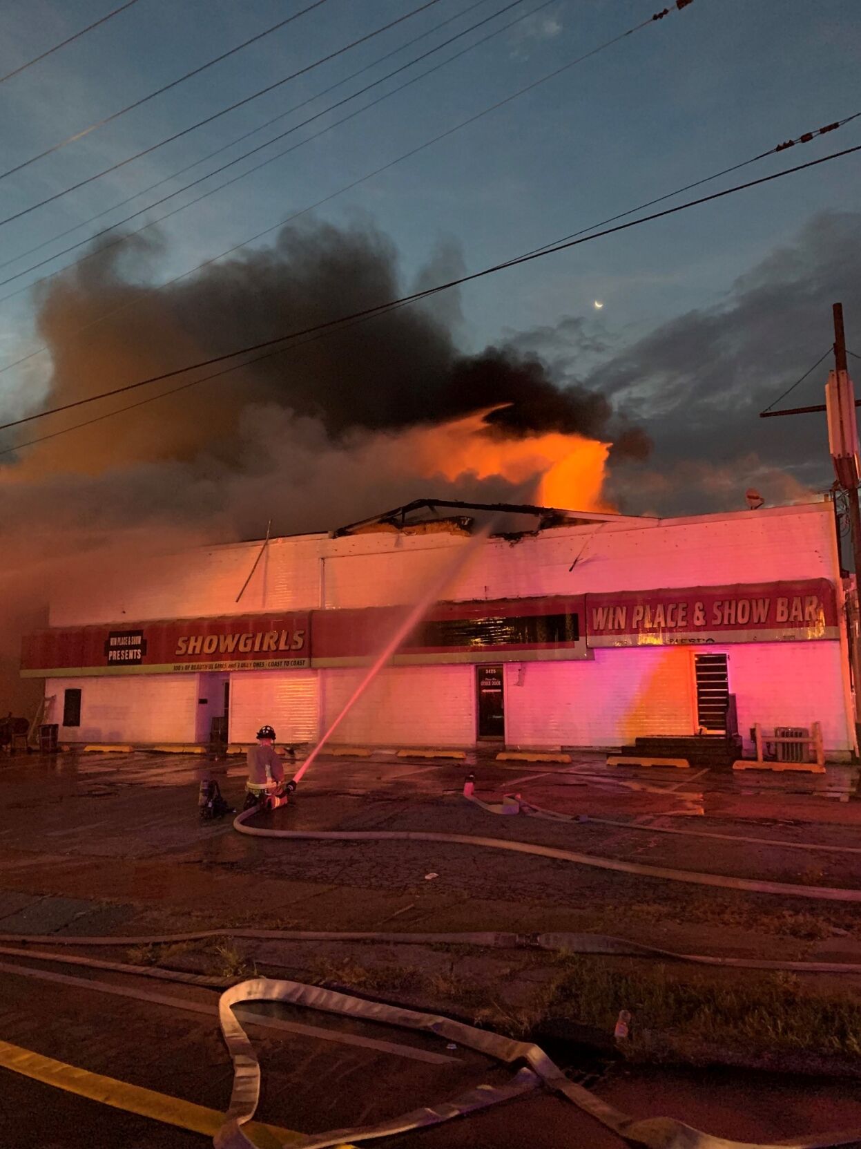 Firefighter kneels to fight showclub fire