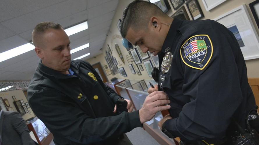 A New Albany police officer putting on a body camera