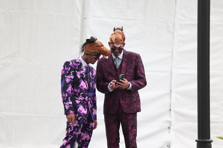 Two men in horse hats check phone.JPG