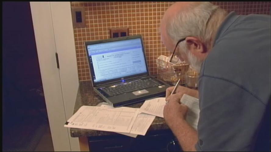 Senior paying filling out tax forms