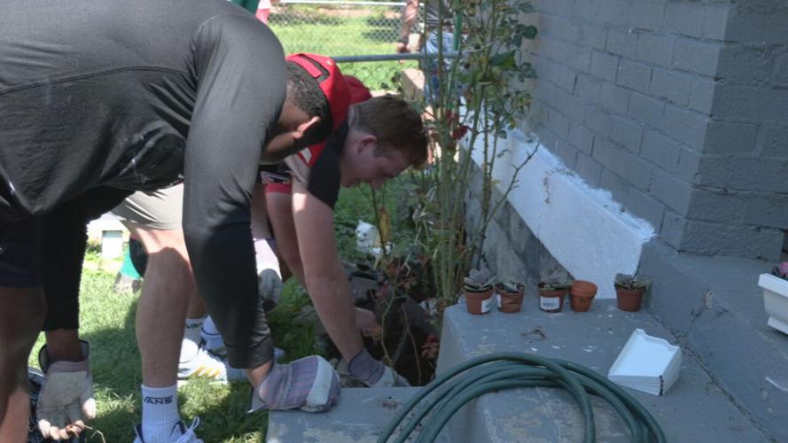 University of Louisville football players help repair a home in the Portland neighborhood