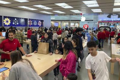 People shop at an Apple store.jpg