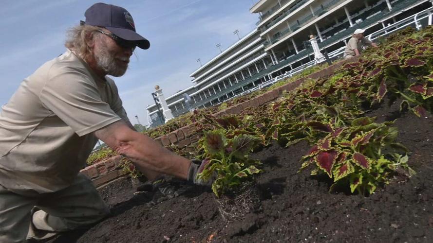 Crew members work to plant around Churchill Downs in preparation for Kentucky Derby 149